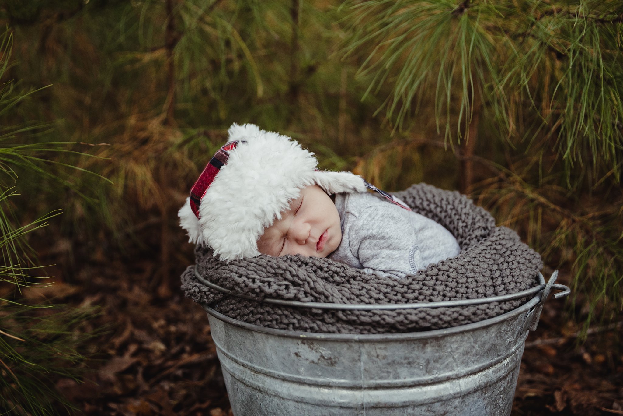 fall newborn boy asleep in bucket for newborn photography