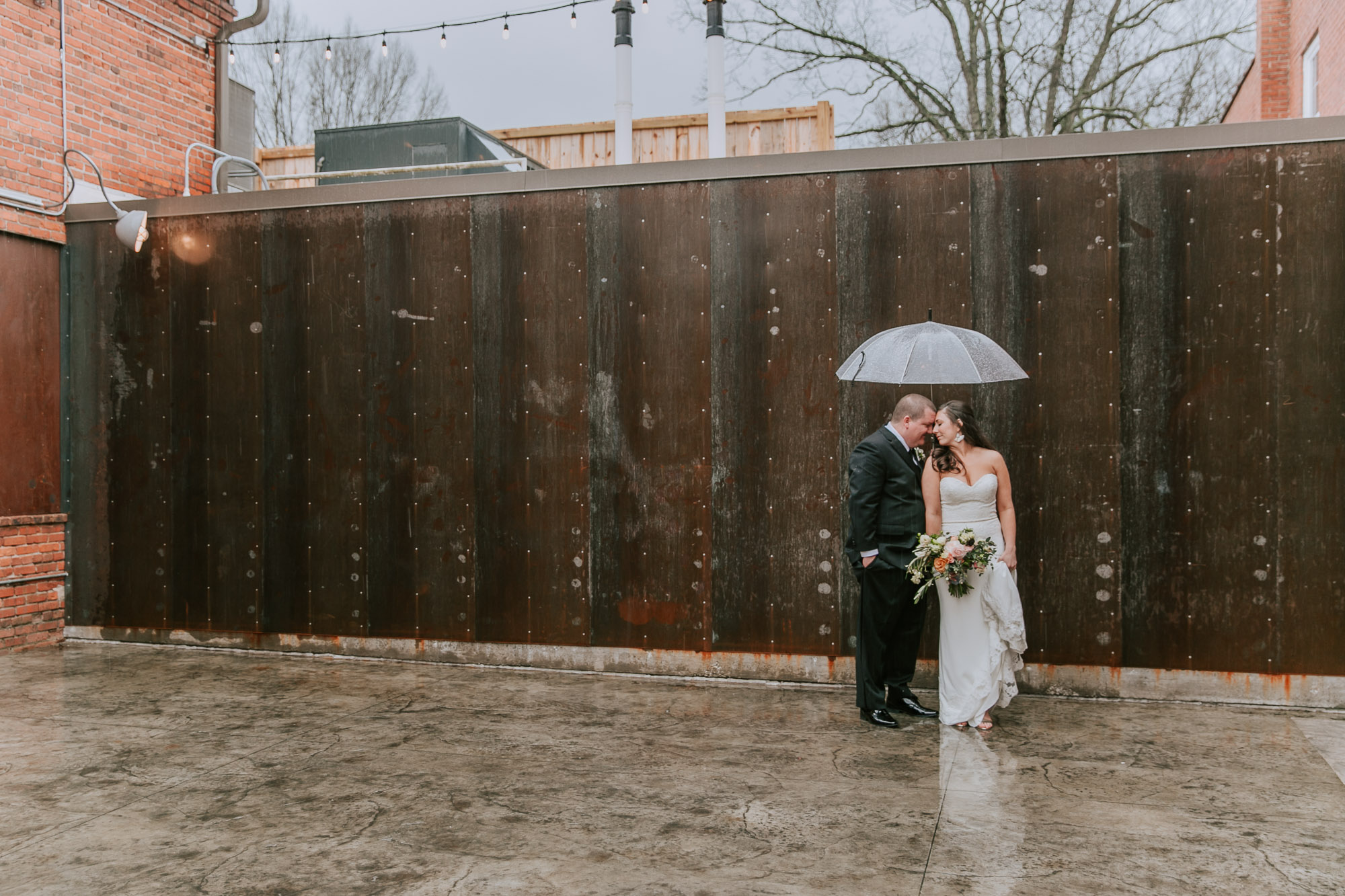 bride & groom in spring rain outside durham cookery