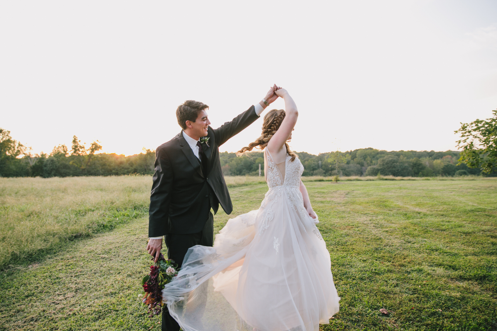 bride and groom twirl at the meadows wedding venue in raleigh